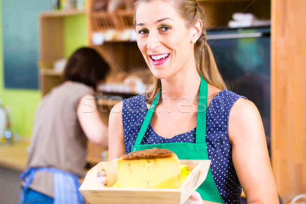 Saleswoman at counter offering cheese Stock photo © Kzenon