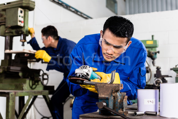 Metal workers in industrial workshop grinding Stock photo © Kzenon