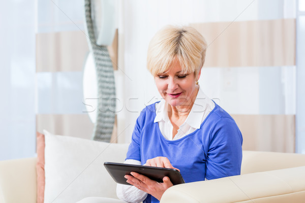 Senior woman using tablet computer at home Stock photo © Kzenon