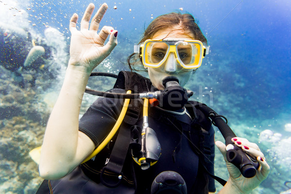 Woman diving on coral reef giving the ok sign Stock photo © Kzenon