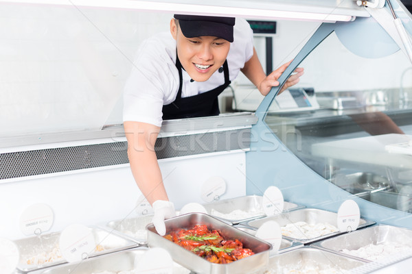 Chef replenishing a tray of food in a display Stock photo © Kzenon