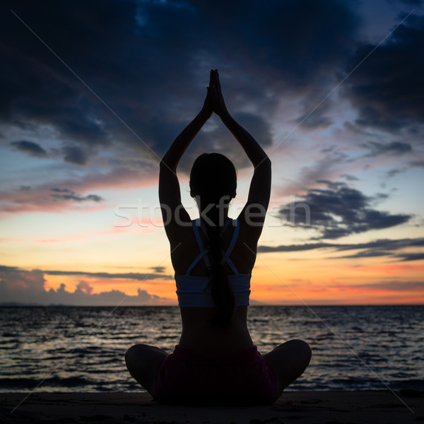 Fit woman sitting in lotus position while practicing yoga on the Stock photo © Kzenon