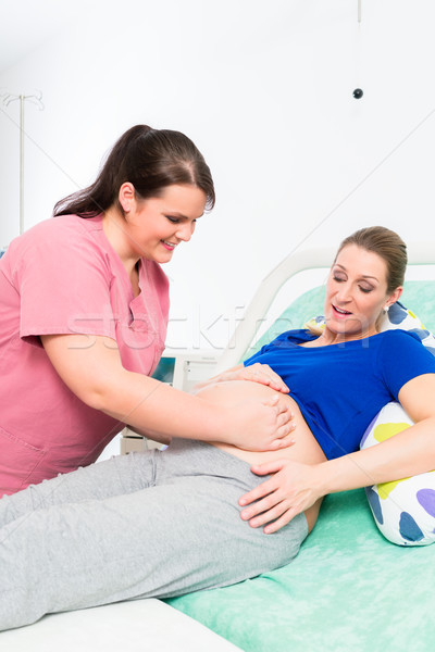Stock photo: Midwife or nurse and pregnant woman in delivery room