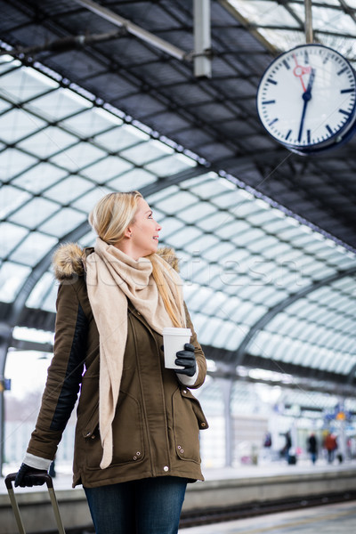 Woman looking at clock in train station as her train has a delay Stock photo © Kzenon