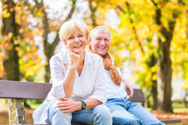 Senior couple sitting on part bench in fall Stock photo © Kzenon