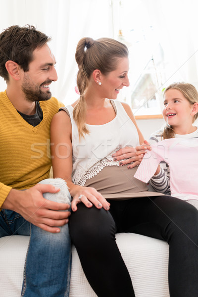 family awaiting offspring and looking at baby clothes Stock photo © Kzenon