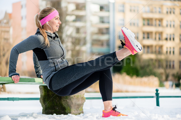 Woman stretching her limbs for sports exercise in winter Stock photo © Kzenon
