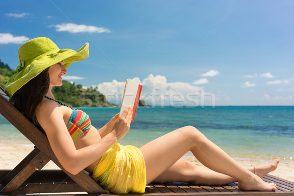 Young beautiful woman reading a book at the beach in a sunny day Stock photo © Kzenon