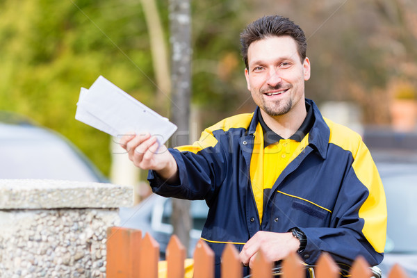 Postman delivering letters to mailbox of recipient Stock photo © Kzenon