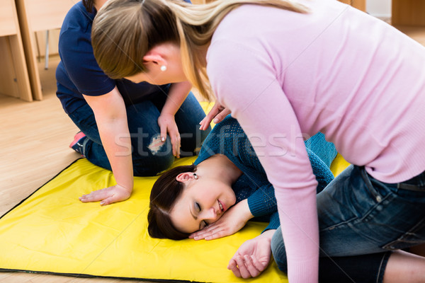Women in first aid class training to position injured person Stock photo © Kzenon
