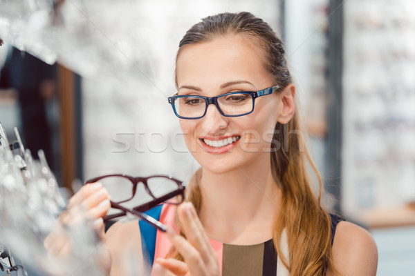 Woman being satisfied with the new eyeglasses she bought in the store Stock photo © Kzenon