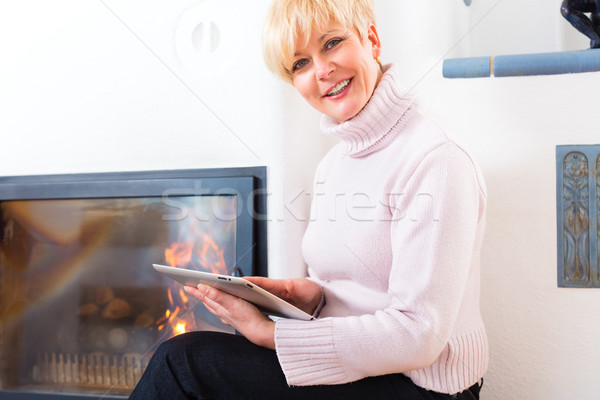 Female Senior at home in front of fireplace Stock photo © Kzenon