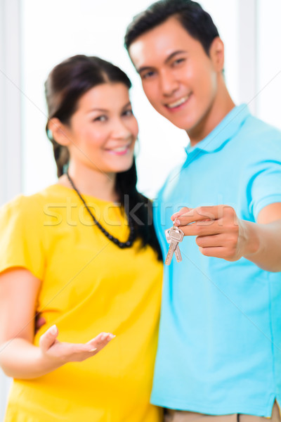 Asian man giving girlfriend key to move in new home Stock photo © Kzenon