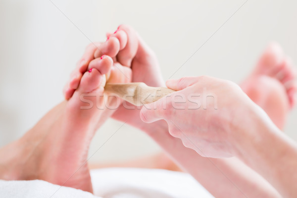 Women at reflexology having foot massaged Stock photo © Kzenon