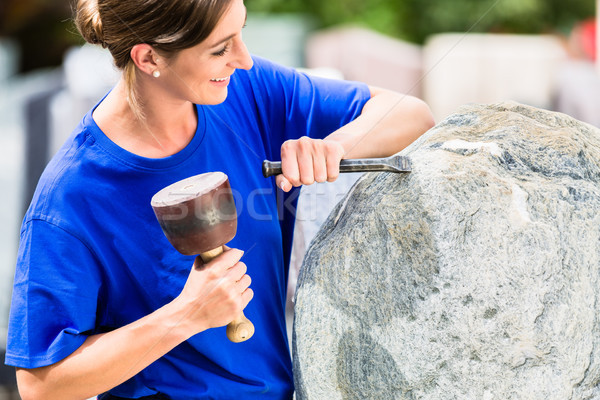 Stock photo: Stonemason working on boulder with sledgehammer and iron
