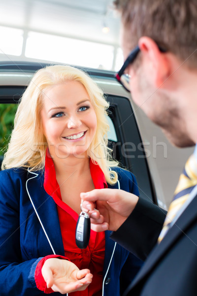 Woman with key to new auto in car dealership Stock photo © Kzenon