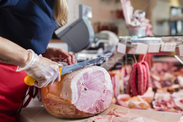 Experienced butcher shop assistant cutting ham Stock photo © Kzenon