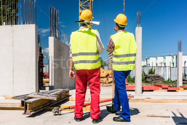 Zwei Arbeitnehmer tragen Sicherheitsausrüstung Planung Arbeit Stock foto © Kzenon