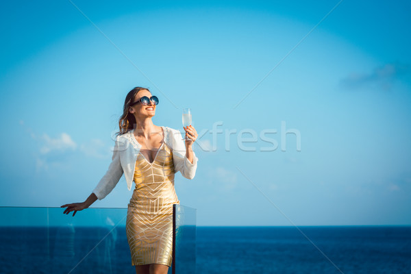 Donna bere frizzante vino guardando Ocean Foto d'archivio © Kzenon