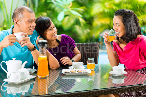 Asian friends having coffee on home porch Stock photo © Kzenon