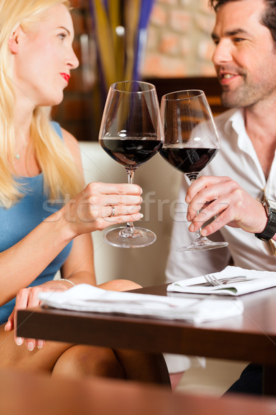 Attractive couple drinking red wine in restaurant or bar Stock photo © Kzenon