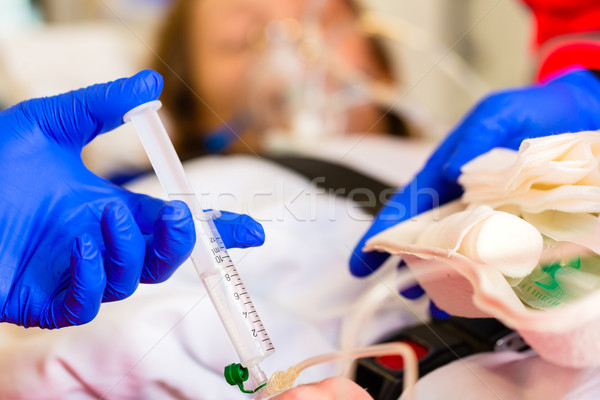 Paramedic giving infusion in ambulance Stock photo © Kzenon