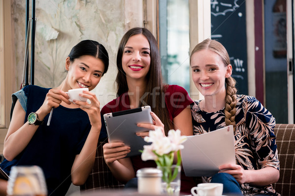 Junge Frauen halten Dateien Cafeteria drei schönen Stock foto © Kzenon