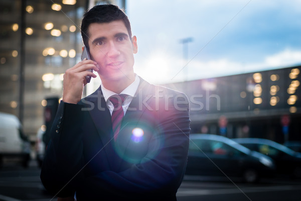 Business man using phone in evening outdoors Stock photo © Kzenon