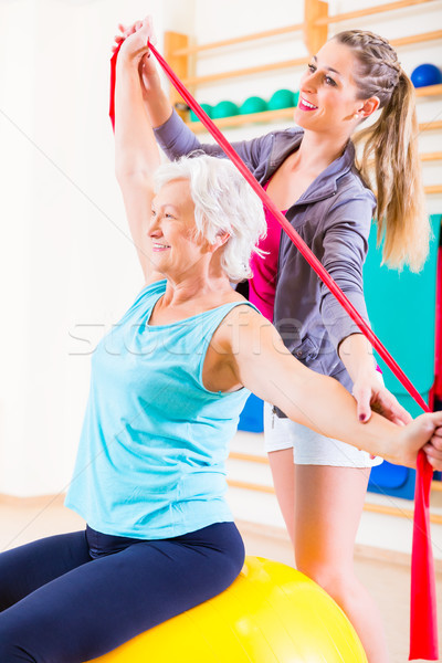 Senior woman with stretch band at fitness Stock photo © Kzenon