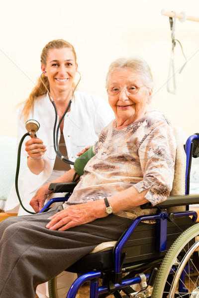 Jovem enfermeira feminino senior casa de repouso pressão arterial Foto stock © Kzenon