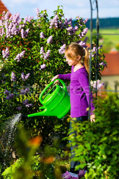 Happy child watering flowers in the garden Stock photo © Kzenon
