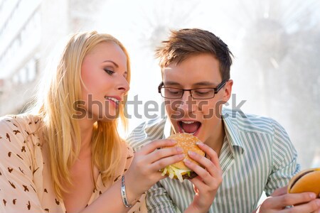 Couple is hungry and eating a burger at break Stock photo © Kzenon