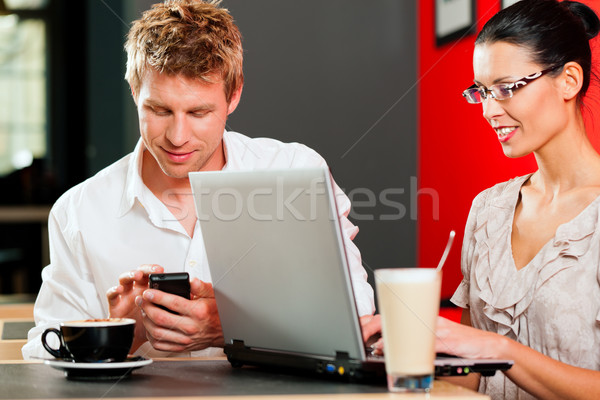 Stock photo: Couple in coffeeshop with laptop and mobile