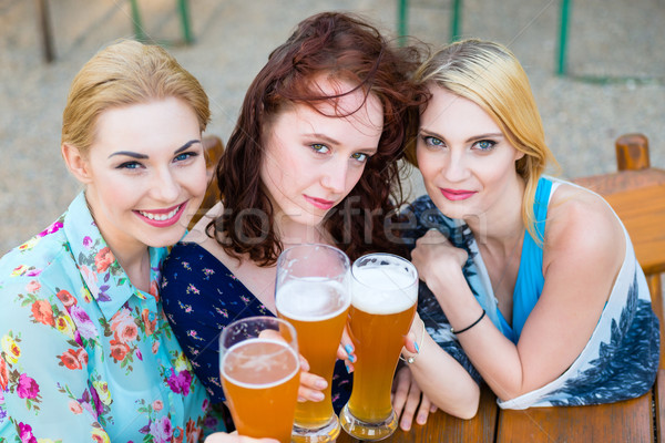 Friends talking and drinking in beer garden Stock photo © Kzenon