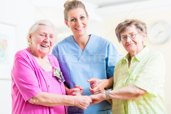 Elderly care nurse with two senior women Stock photo © Kzenon