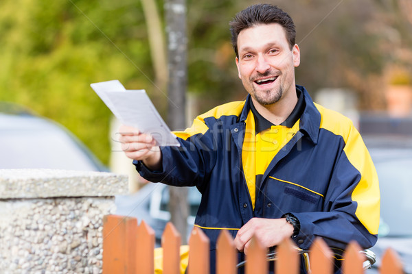 Postman delivering letters to mailbox of recipient Stock photo © Kzenon