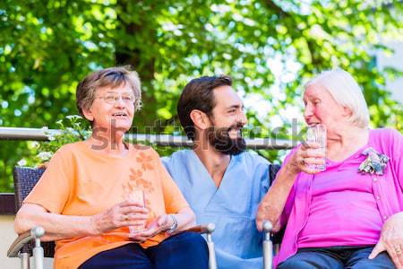 Senior women in rest home with geriatric nurse Stock photo © Kzenon