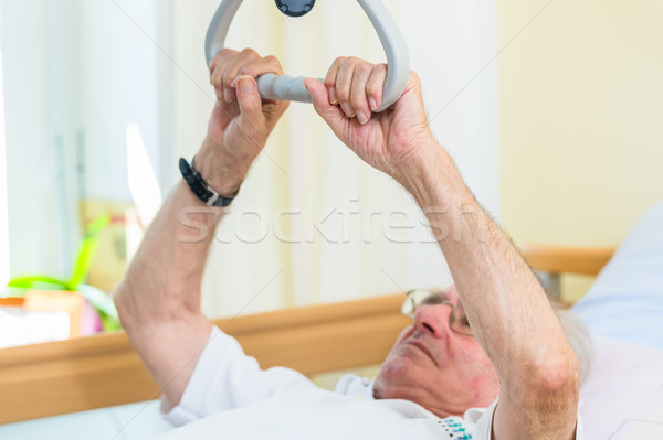 Senior man grabbing handle to get out of bed  Stock photo © Kzenon