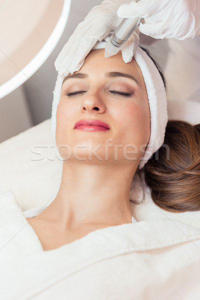 Close-up of the face of a beautiful woman smiling during facial treatment Stock photo © Kzenon