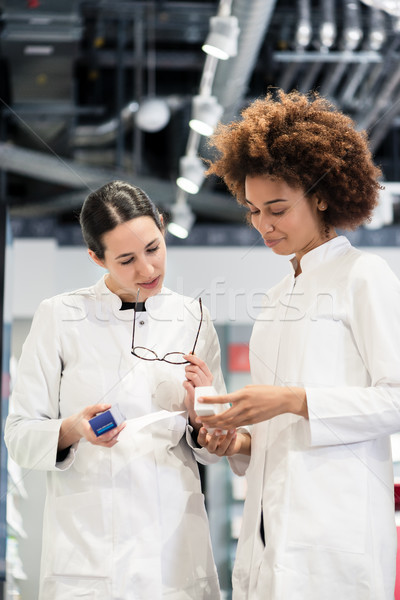 Reliable pharmacists analyzing a prescription and two different packages Stock photo © Kzenon