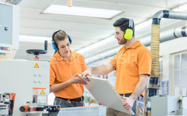 Stock photo: Carpenter in furniture factory inspecting piece in QA