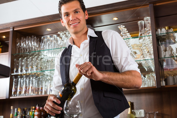 Barman standing behind bar with wine Stock photo © Kzenon