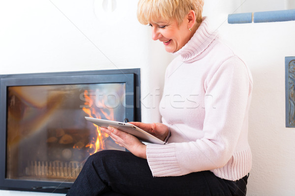 Female Senior at home in front of fireplace Stock photo © Kzenon