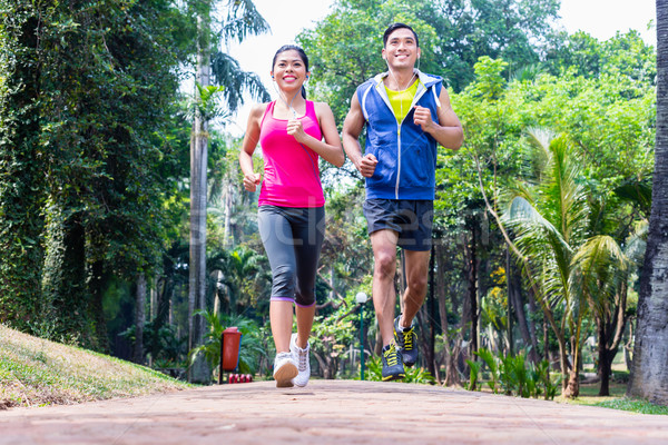 Asian couple jogging or running in park for fitness Stock photo © Kzenon