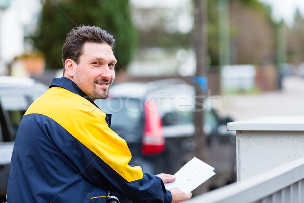 Postman delivering letters to mailbox of recipient Stock photo © Kzenon