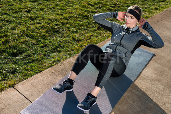 Young woman doing crunches for the abdominal muscles outdoors in Stock photo © Kzenon