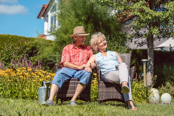 Happy senior couple in love relaxing together in the garden in a Stock photo © Kzenon