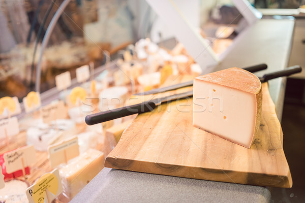 Cheese on a board at counter in delicatessen shop Stock photo © Kzenon