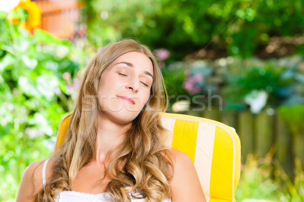 Woman tanning in her garden on lounge chair Stock photo © Kzenon