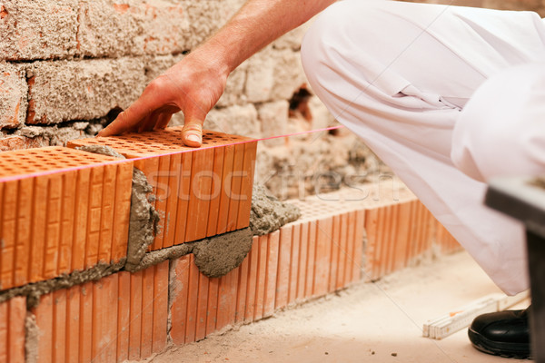 Stock photo: bricklayer making wall with brick and grout